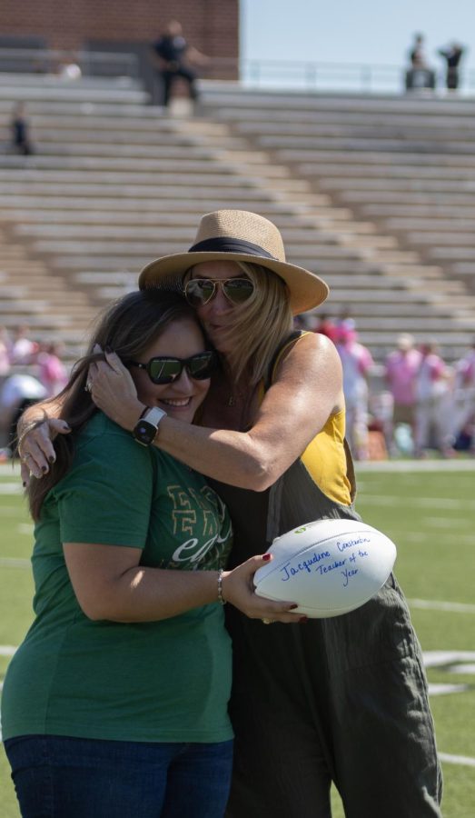 Teacher being hugged by principal.