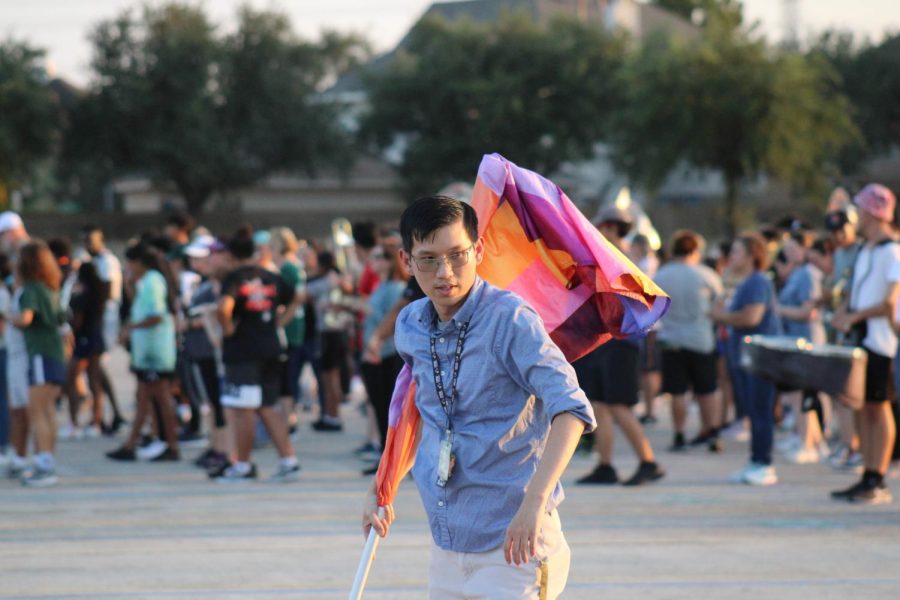 Teacher learns color guard with students.